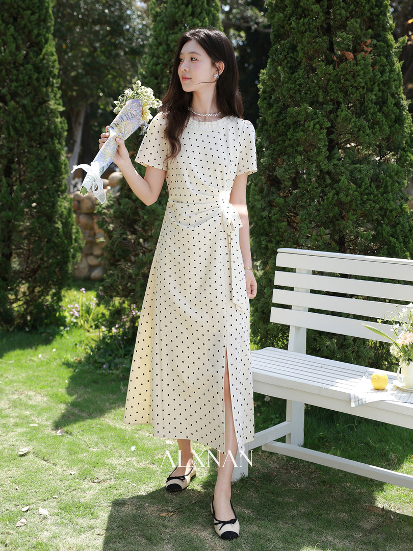 Woman wearing a cream polka dot midi dress outdoors