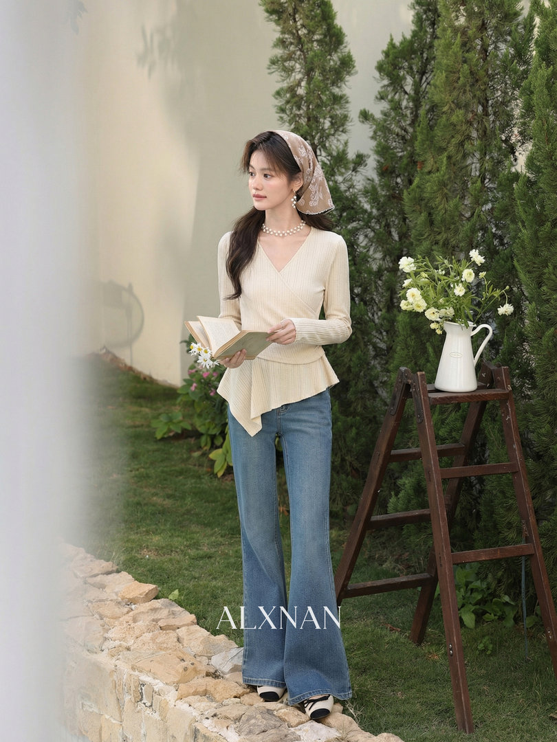 Woman modeling a cream wrap top with blue flared jeans outdoors