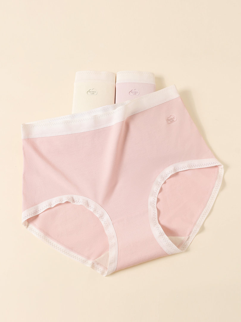 Pink and white women's underwear panties laid flat on a beige background