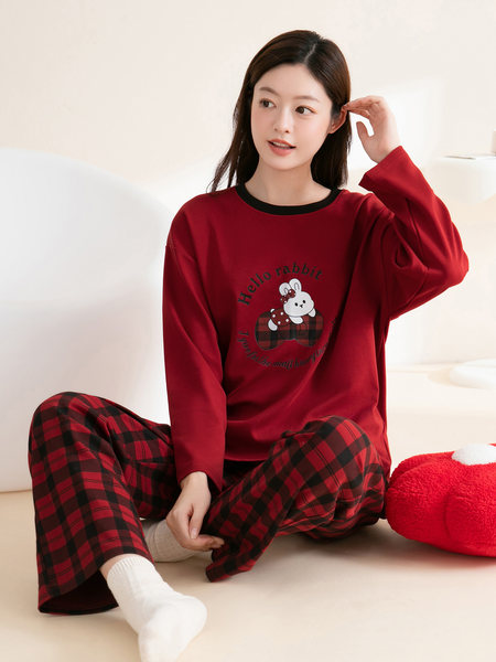 Model wearing a red pajama set with a cartoon rabbit print and plaid pants