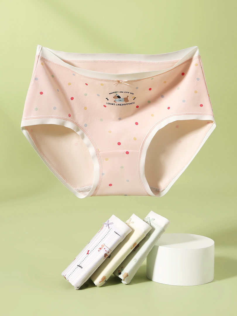Pastel polka dot women's briefs displayed on a green background