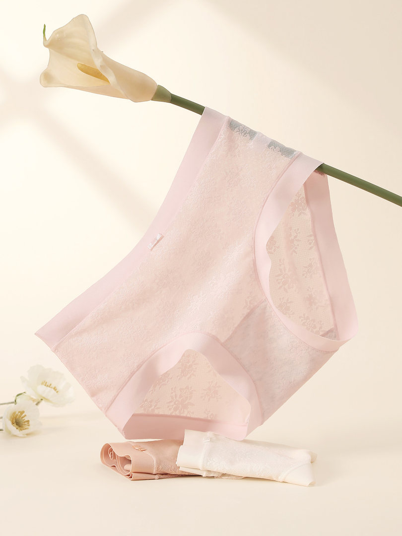 Pink lace underwear displayed on a hanger
