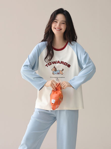 Model wearing a light blue and cream cartoon loungewear pajama set