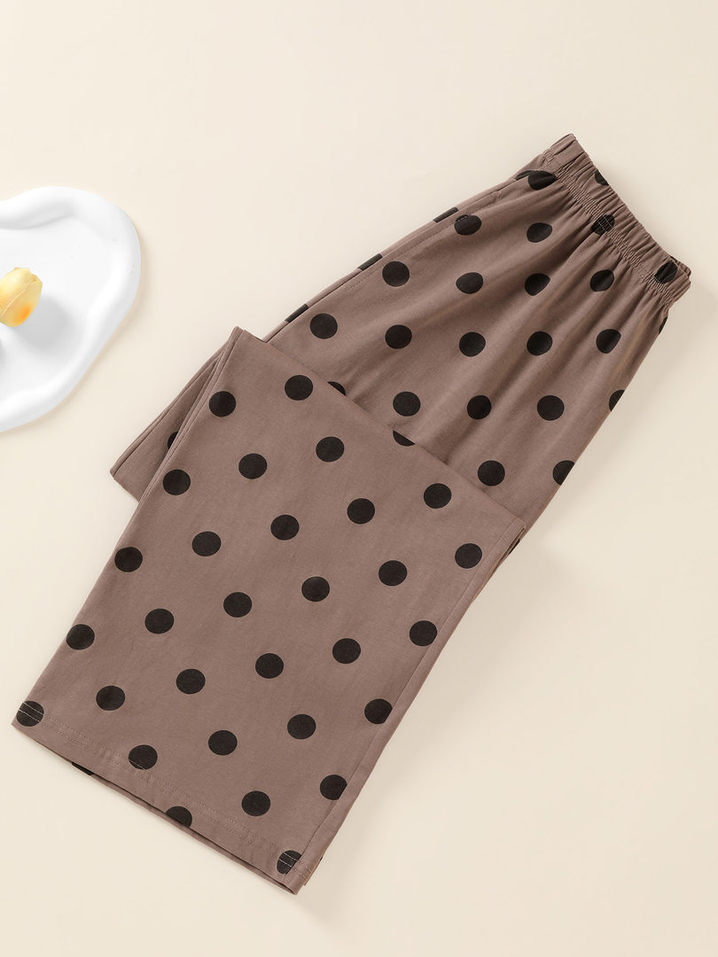 Brown polka dot pants laid flat on a neutral background