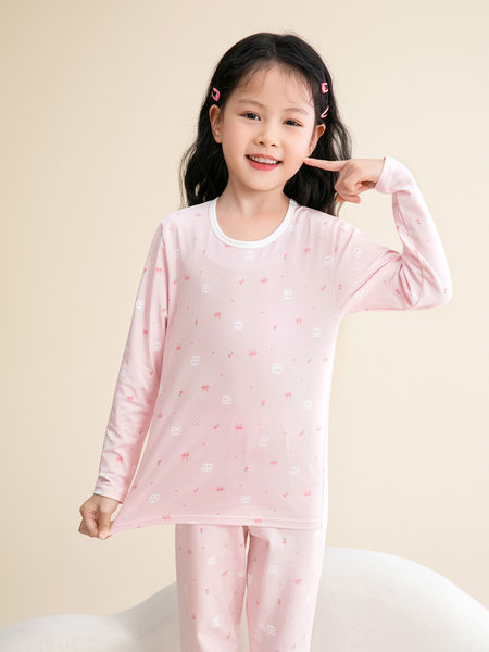 Child wearing a pink long-sleeve pajama set with small print pattern