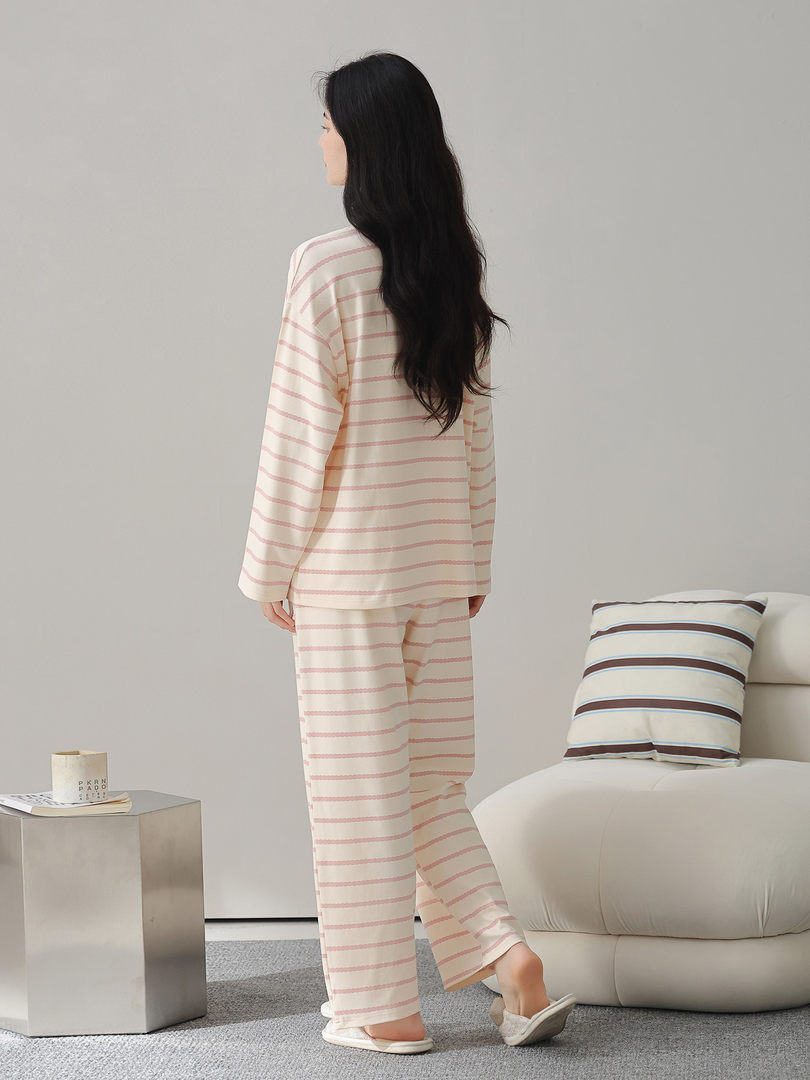 Woman wearing a cream and pink striped loungewear pajama set