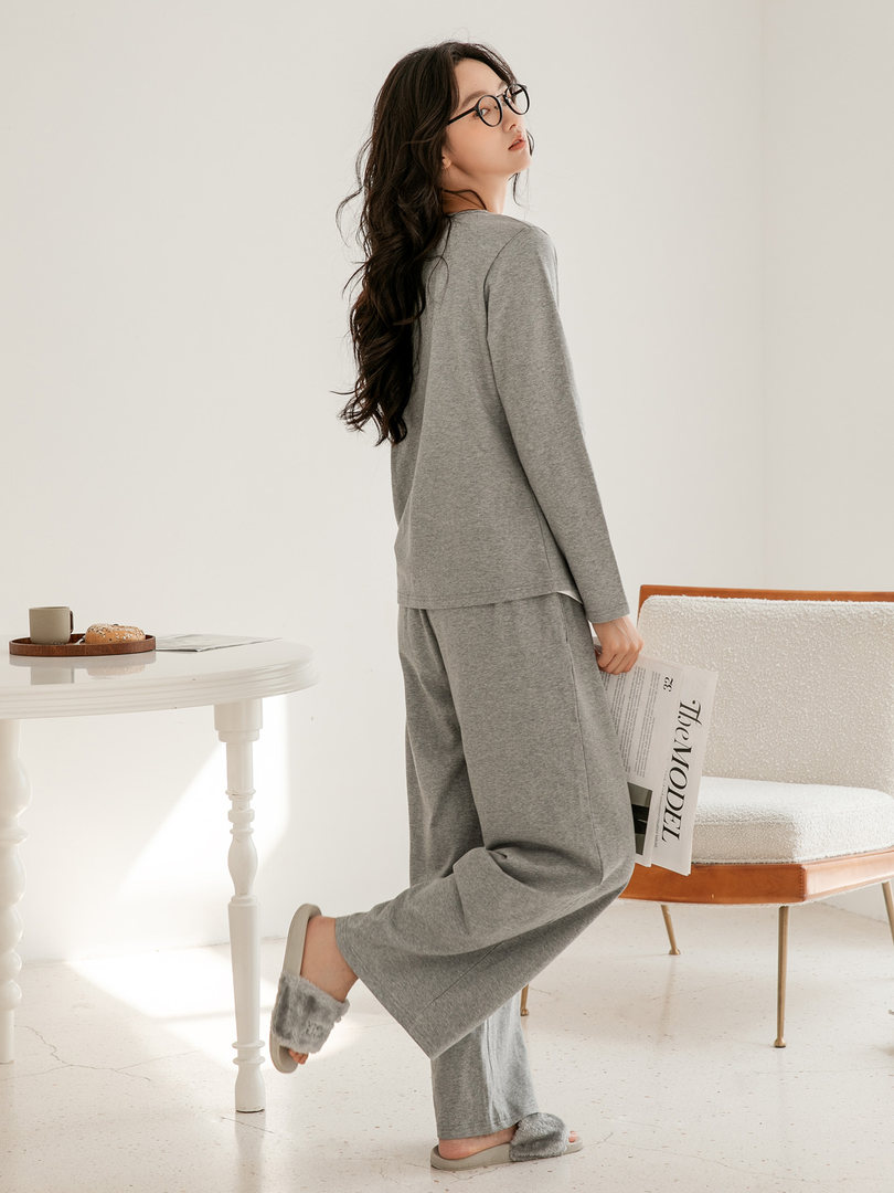 Woman wearing a gray long-sleeve loungewear set with matching pants