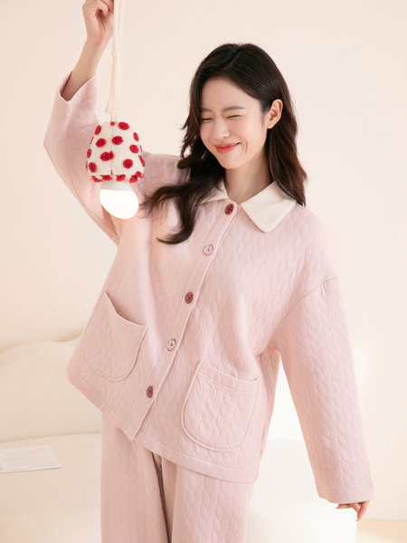 Pink quilted loungewear set worn by a model holding a polka dot plush accessory