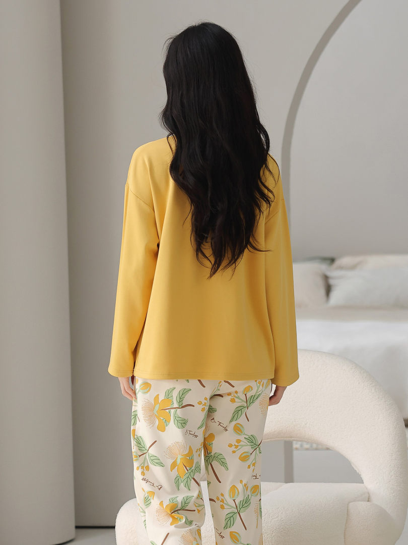 Model wearing a yellow long-sleeve loungewear set with floral pajama pants