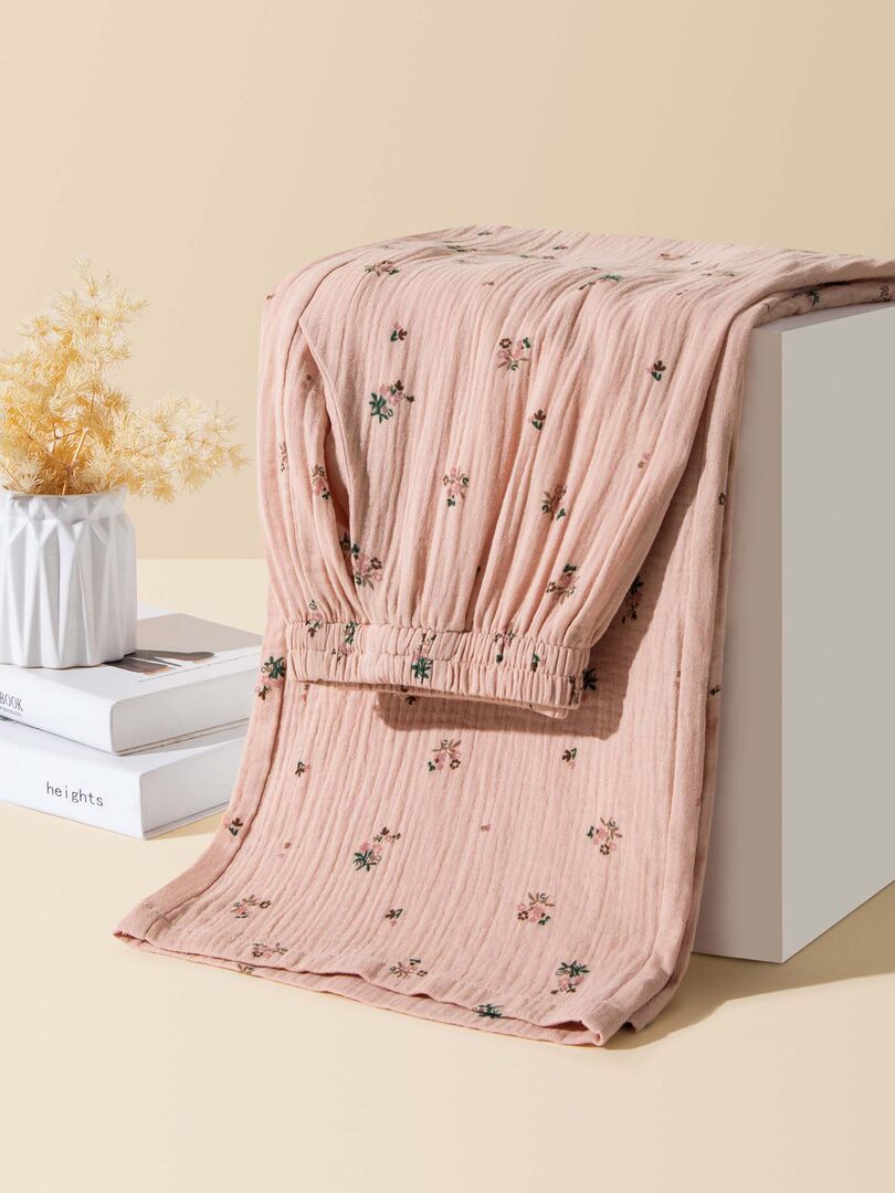 Pink floral textured garment draped over a display block