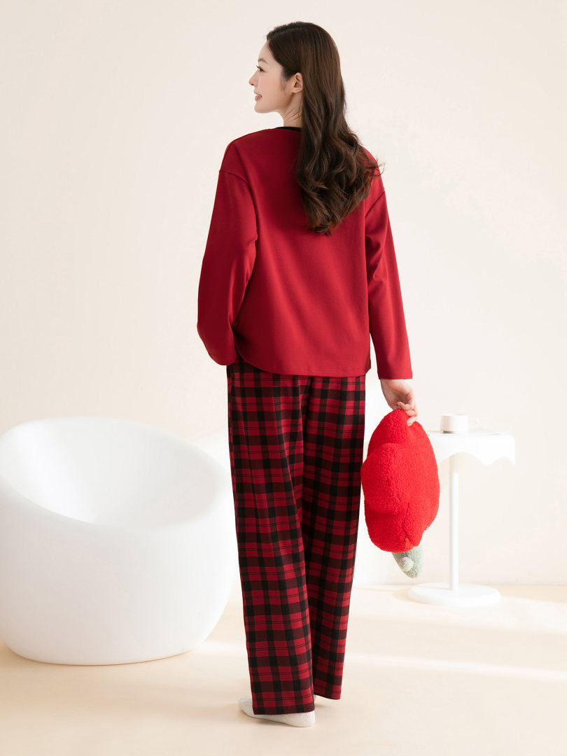 Model wearing a red long-sleeve top with red and black plaid pants