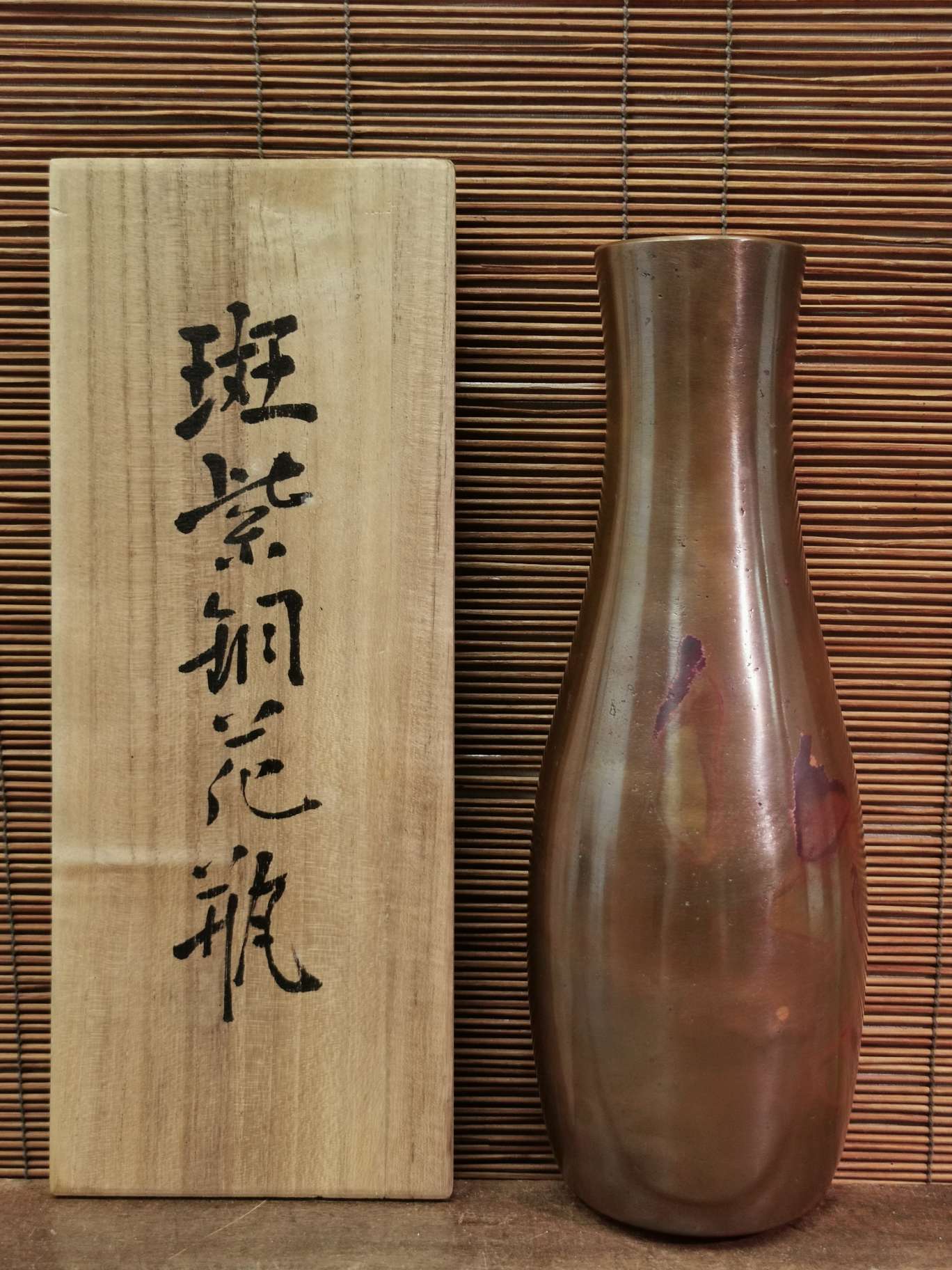 日本晴云作斑紫铜花瓶一个，重1000克，高25厘米，口径3厘米。