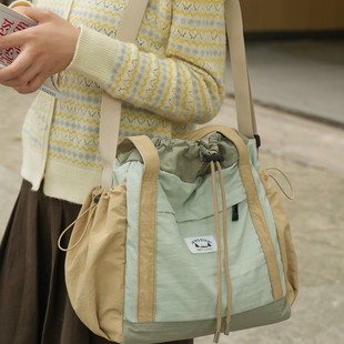 日本高端男单肩包潮流斜挎包抽绳时尚轻便运动大容量单肩斜挎包女