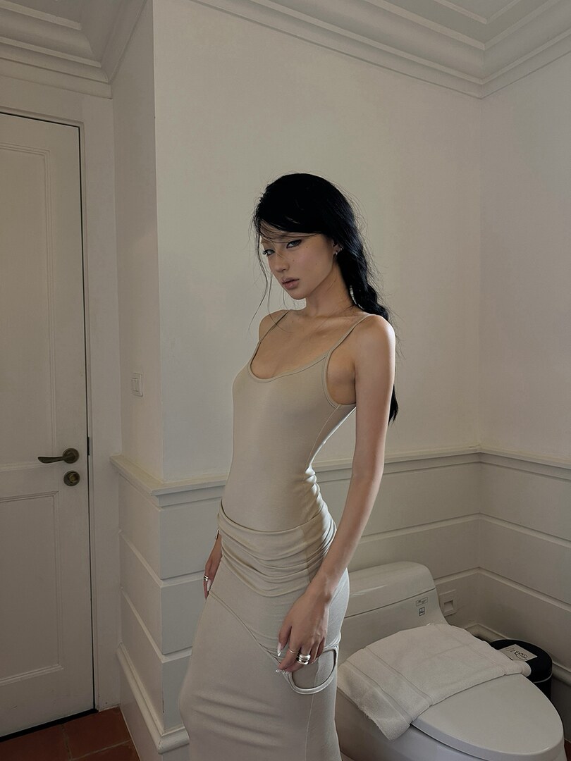Beige fitted spaghetti-strap dress worn by a model indoors