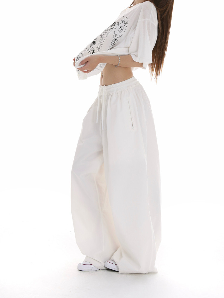 White oversized graphic T-shirt with loose wide-leg pants worn by a model