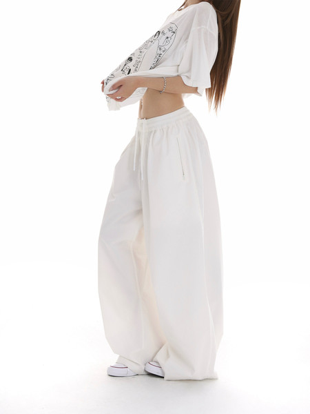 White oversized graphic T-shirt with loose wide-leg pants worn by a model
