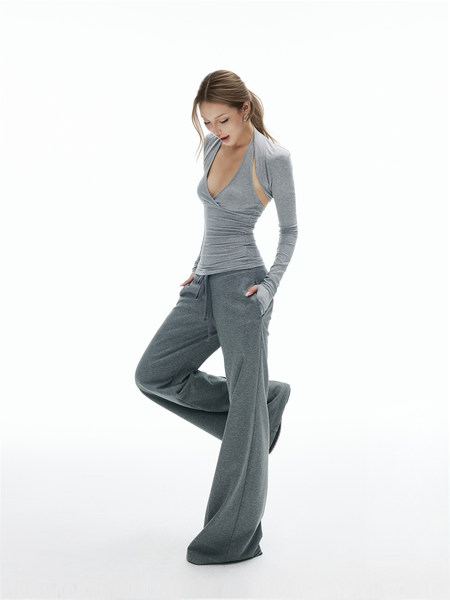Woman wearing a gray long-sleeve wrap top and wide-leg lounge pants