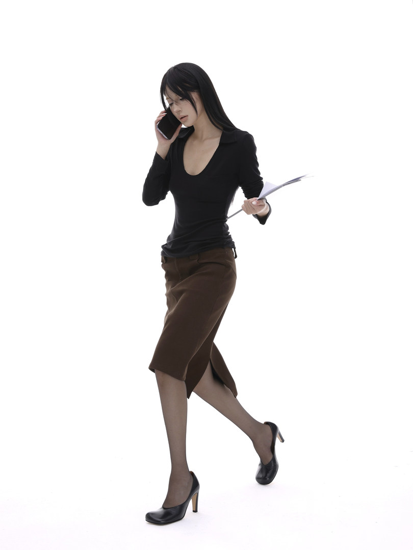 Woman wearing a black top, brown pencil skirt, and black heels