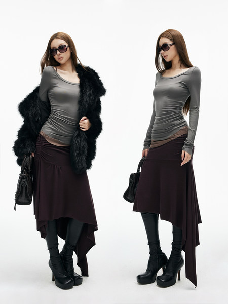 Two models wearing a gray top with a dark long skirt, fur coat, and black boots