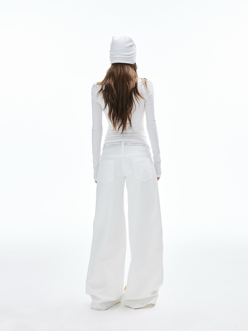 Model wearing a white long-sleeve top with wide-leg white pants and a white beanie