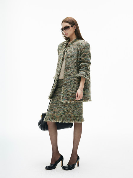 Model wearing a textured tweed jacket and matching skirt with heels