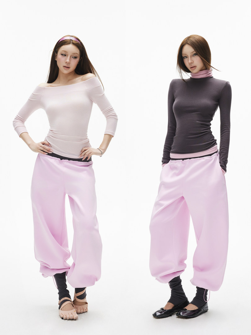 Two models wearing pastel pink wide-leg pants with fitted tops