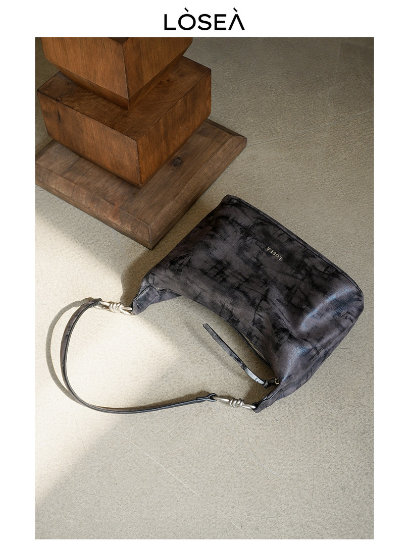 Black shoulder handbag with a long strap and logo detail