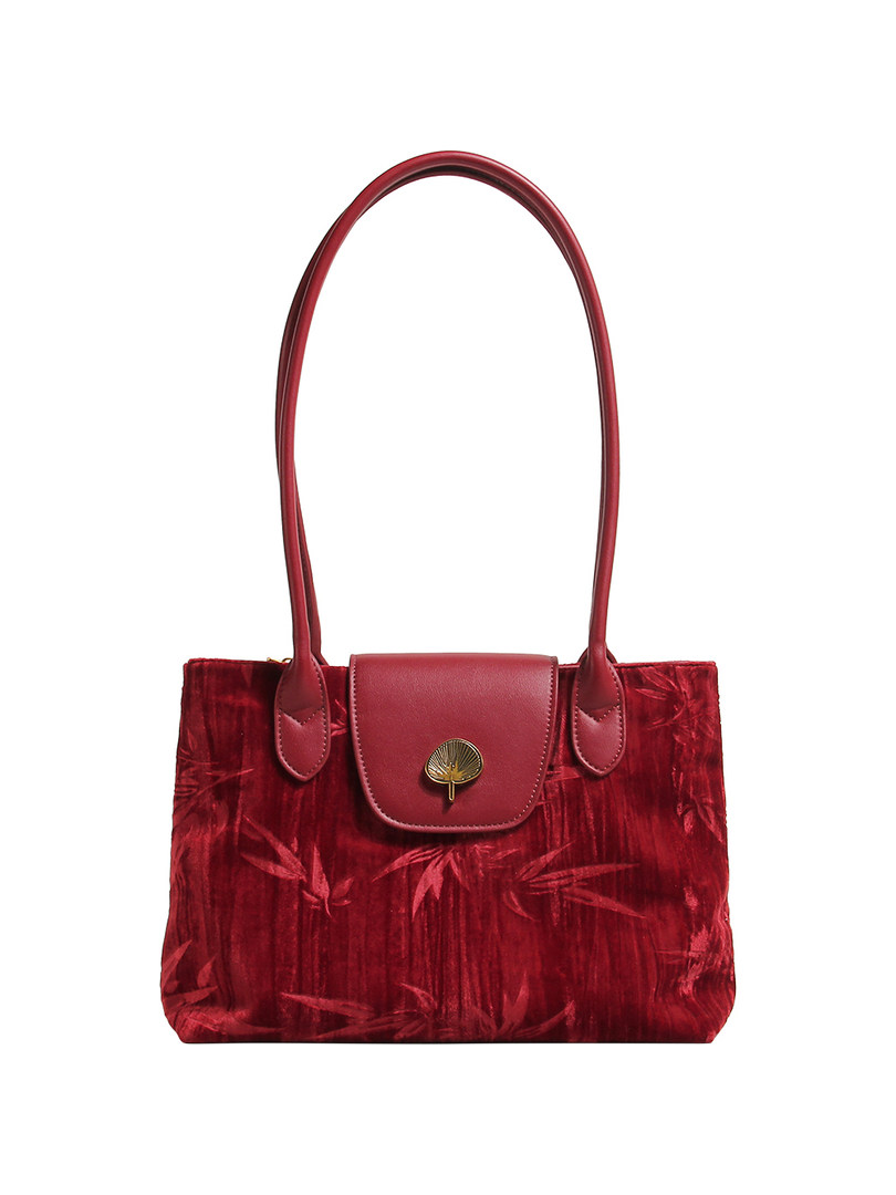 Red leather handbag with long handles on a white background