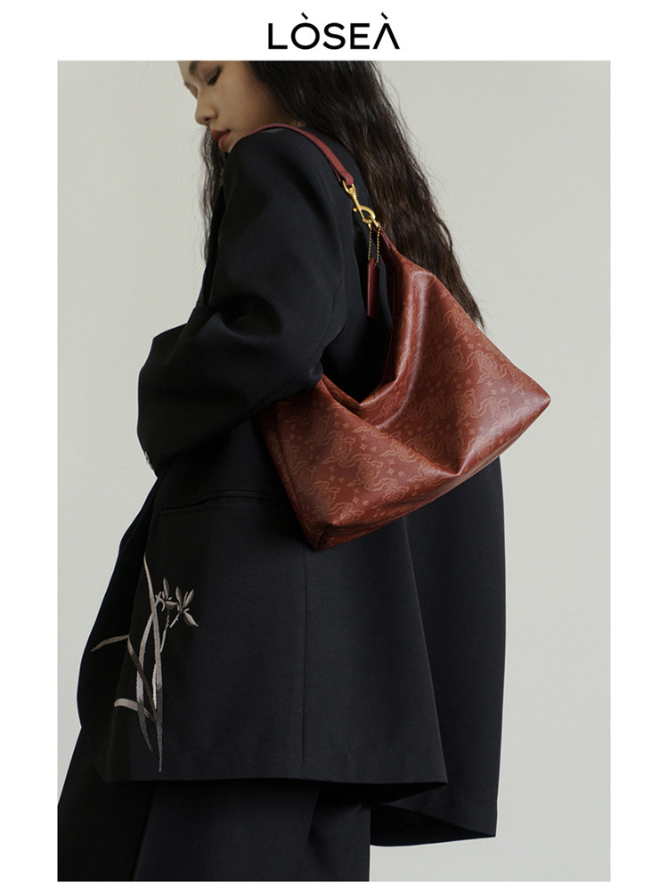 Reddish brown leather shoulder bag worn by a model