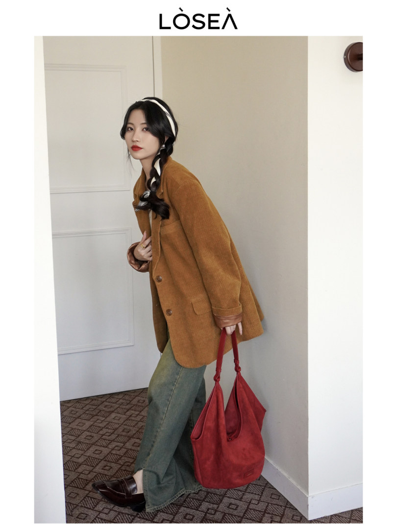 Model wearing a brown corduroy blazer with green pants and a red handbag