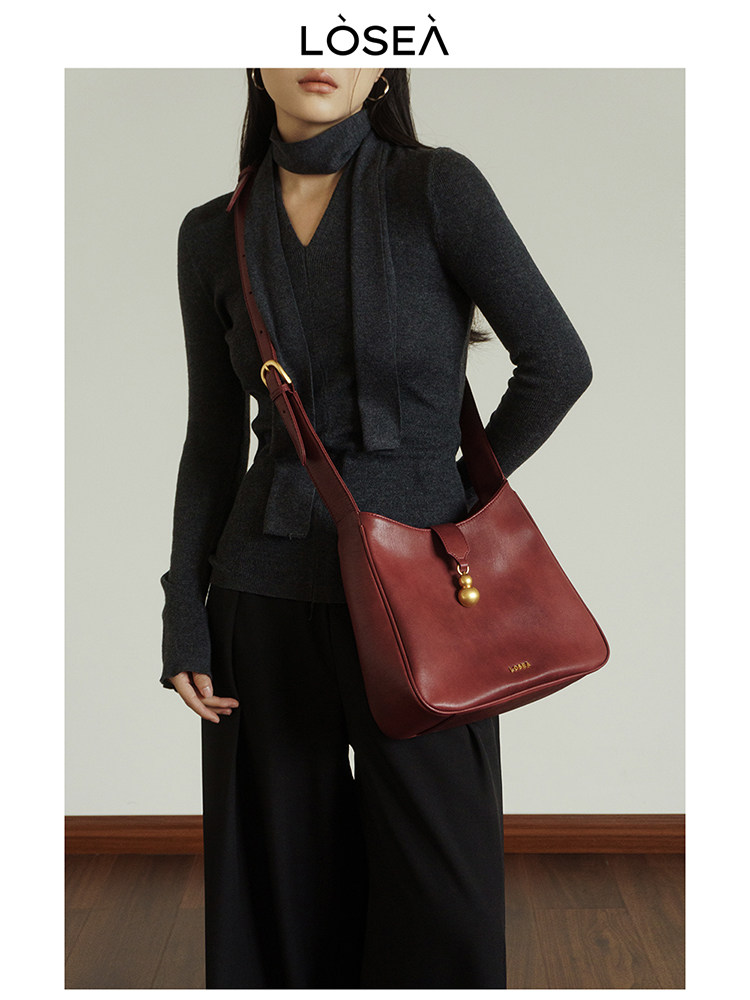 Burgundy leather shoulder bag worn by a model