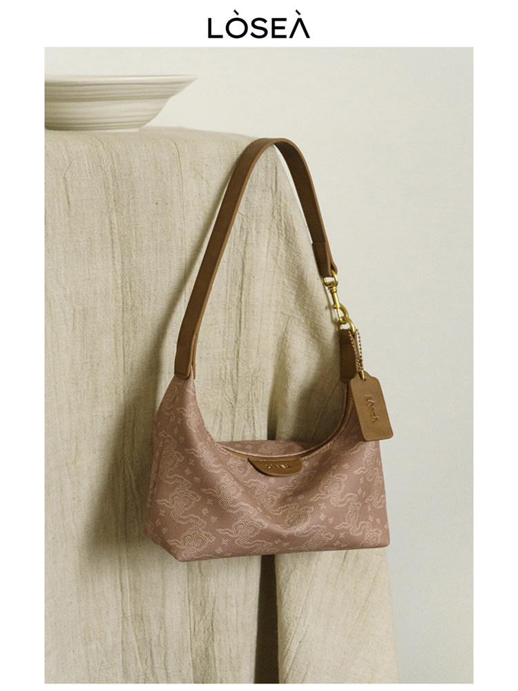 Pink patterned shoulder handbag with brown strap and gold hardware