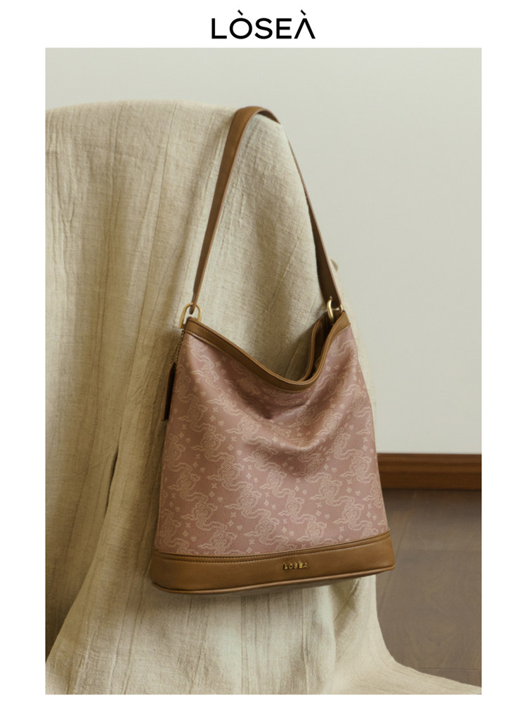Pink patterned shoulder handbag with brown trim and strap