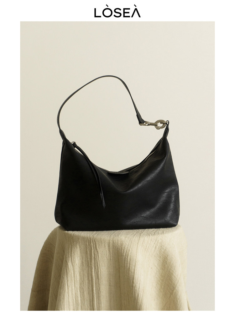 Black leather shoulder handbag displayed on a light background