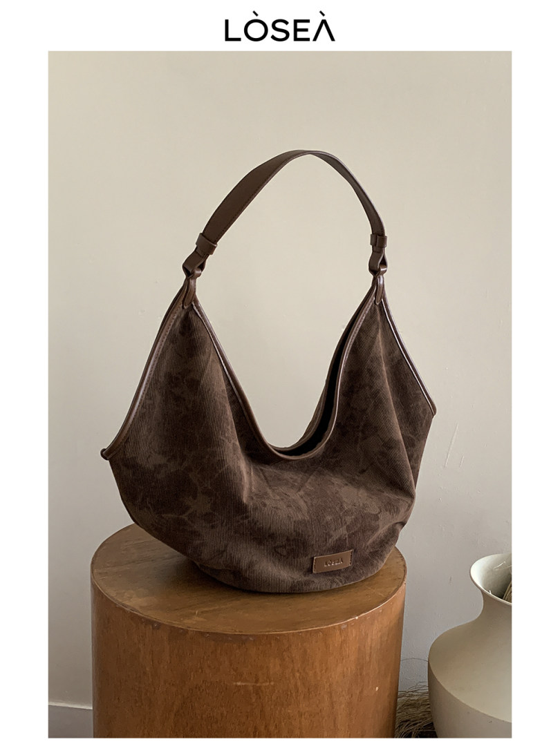 Brown slouchy shoulder bag displayed on a stool