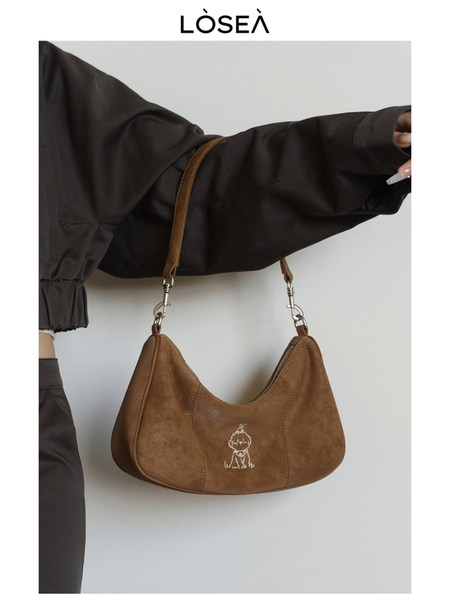 Brown shoulder handbag worn with a black outfit