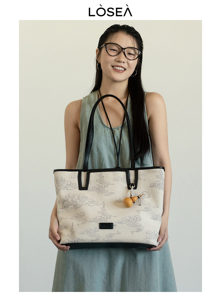 Model holding a patterned tote handbag