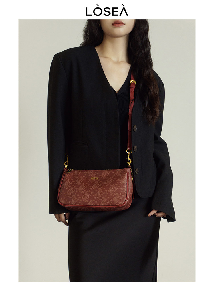 Red patterned shoulder handbag worn with a black blazer outfit