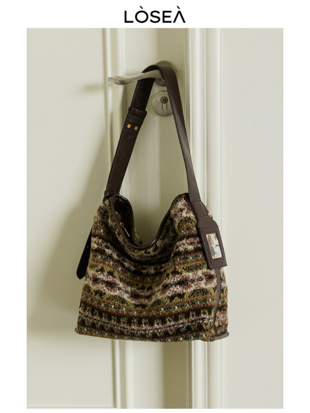 Multicolored textured shoulder bag hanging on a door