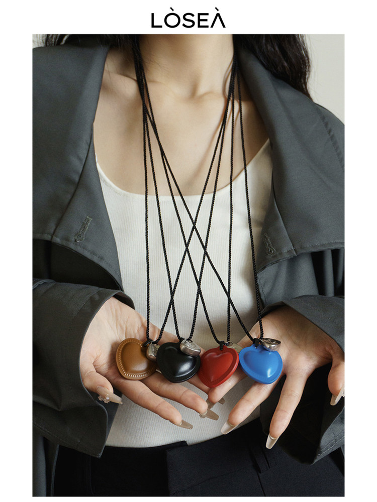 Model wearing a necklace with colorful heart-shaped pendants
