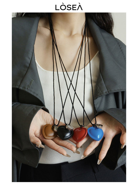 Model wearing a necklace with colorful heart-shaped pendants