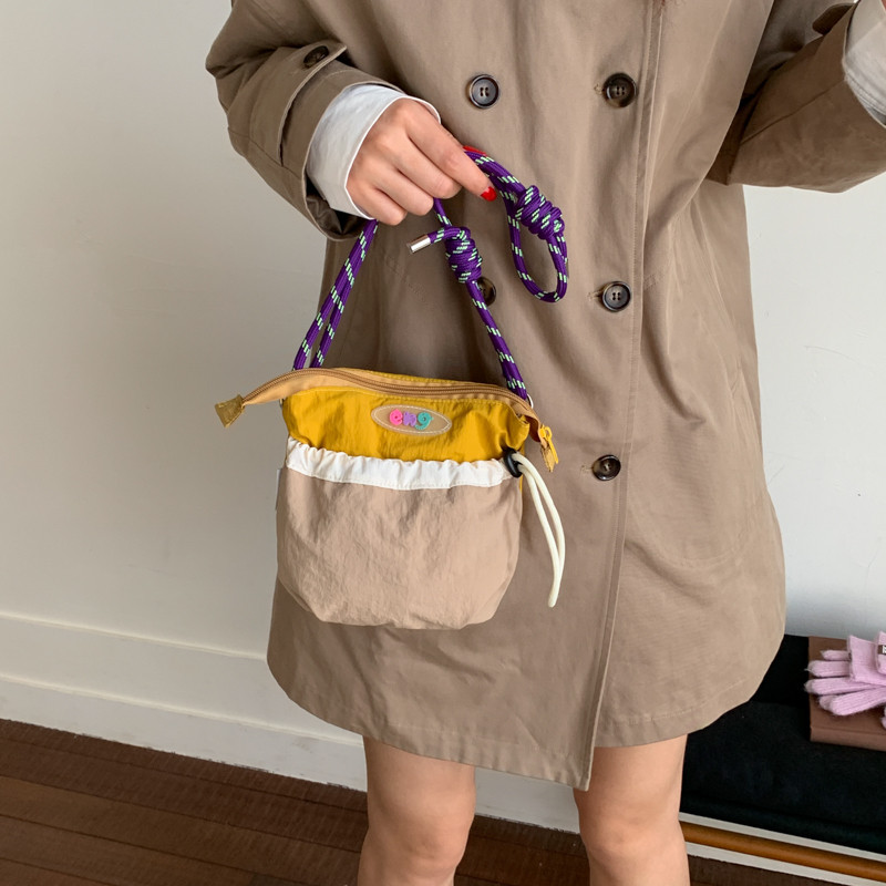 撞色拼接尼龙布手机包2026新款女百搭轻便抽绳束口斜挎包迷你小包