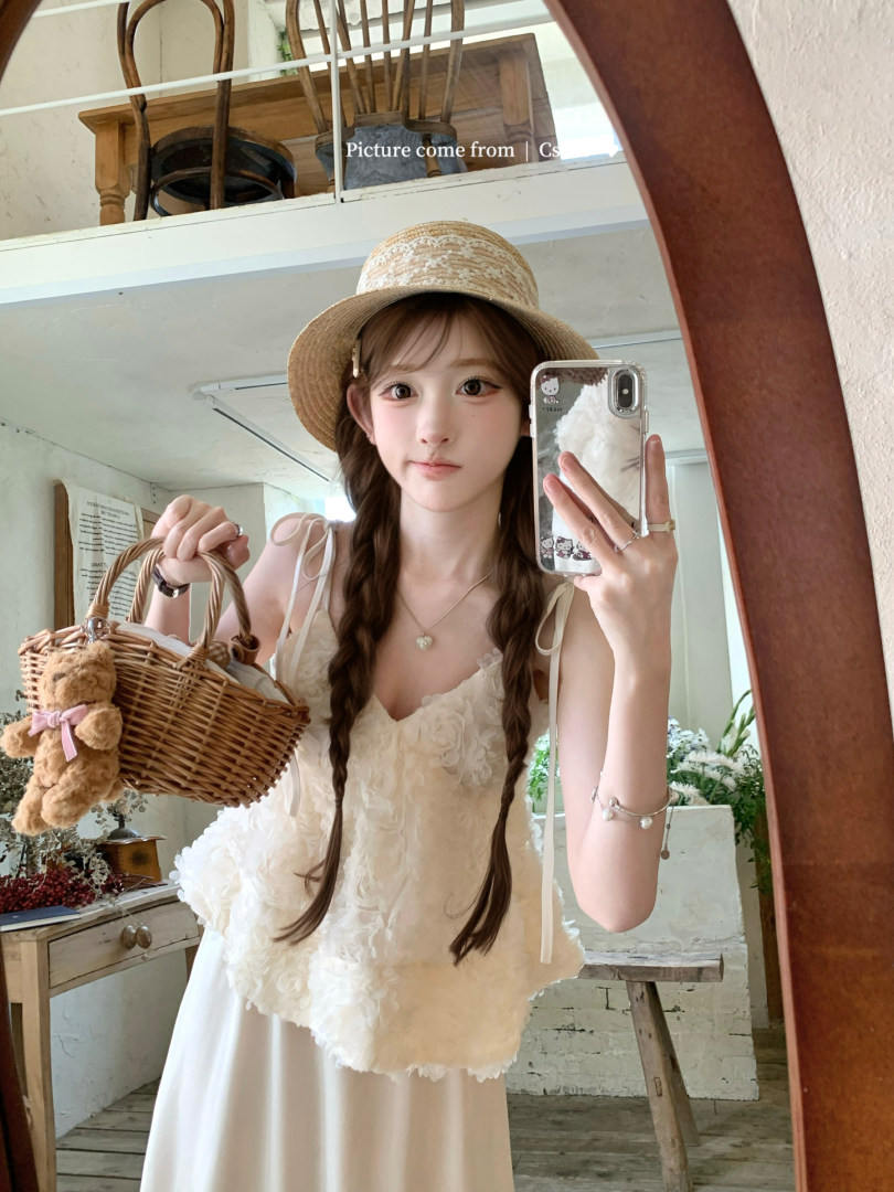 Model wearing a white floral lace dress with a straw hat and wicker basket
