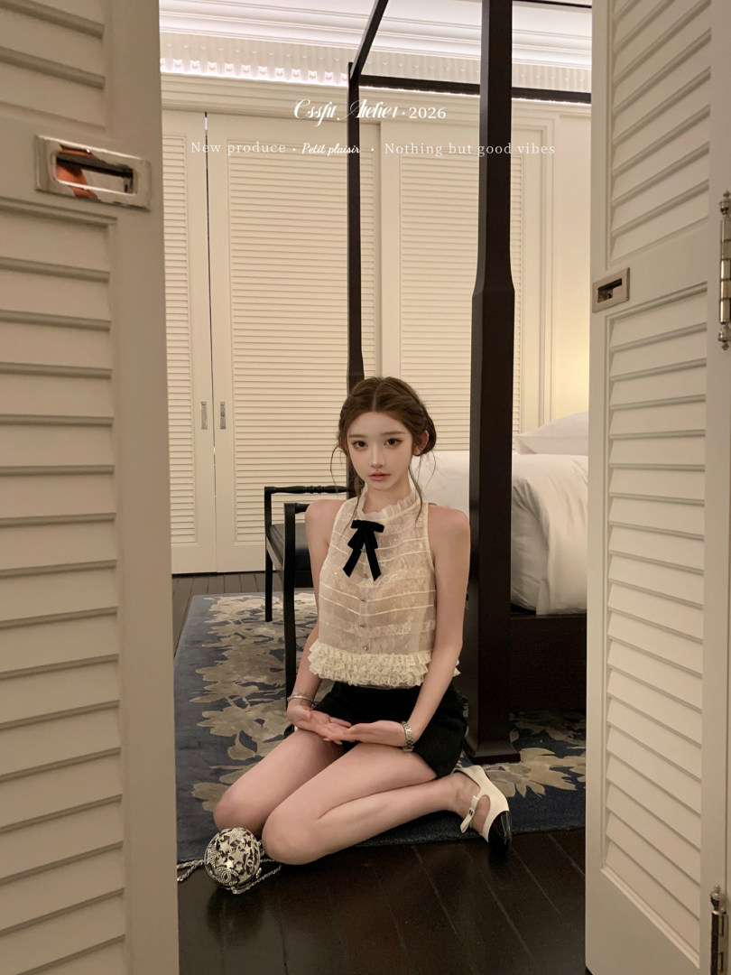 Woman wearing a sheer lace halter top with a black mini skirt and heels