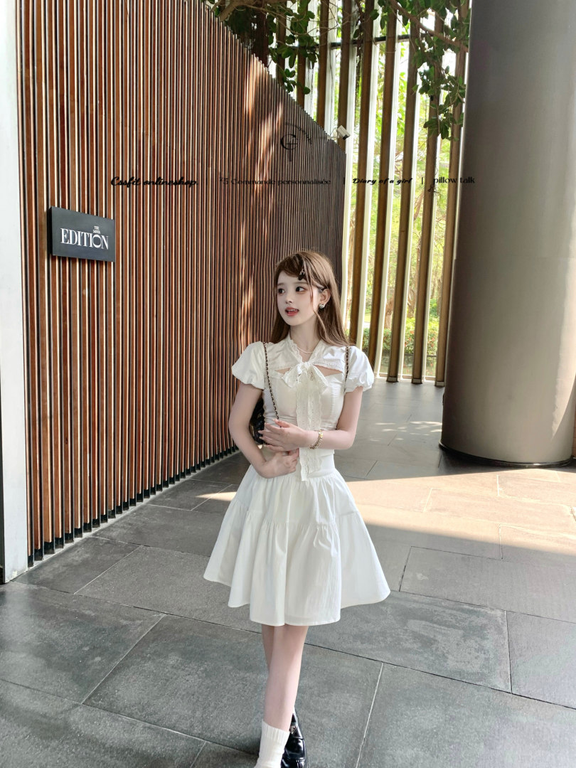 Young woman wearing a white short-sleeve dress outdoors