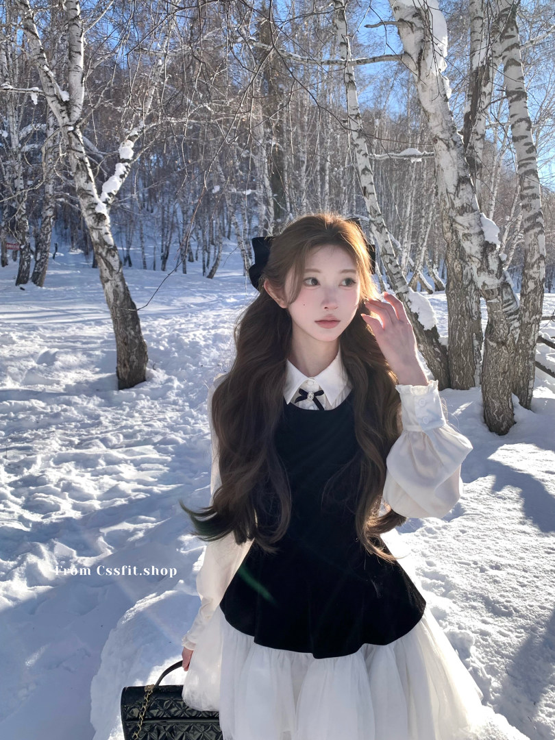 Woman wearing a black-and-white winter outfit in a snowy forest