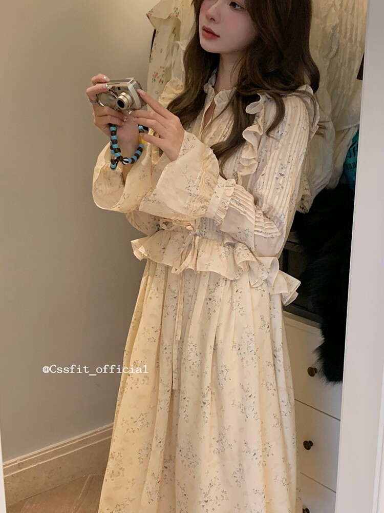 Long cream floral dress with ruffled details worn by a model