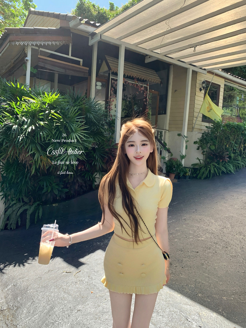 Woman wearing a pale yellow short-sleeve matching top and skirt set outdoors