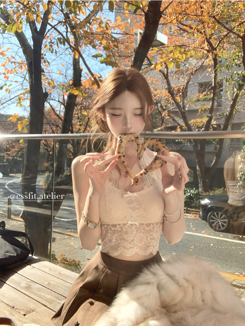 Woman wearing a cream lace crop top and brown skirt outdoors in autumn