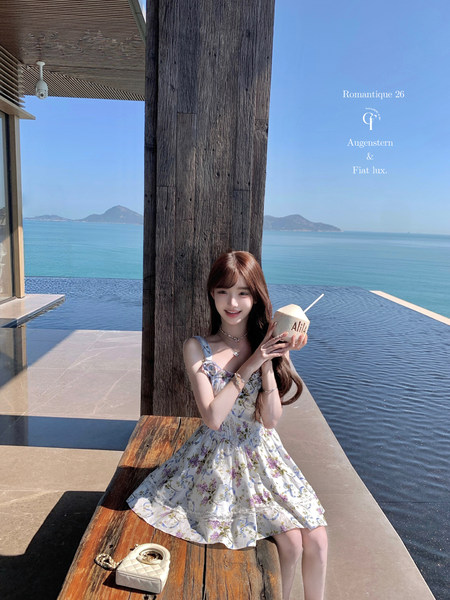 Woman wearing a floral sleeveless summer dress by the sea
